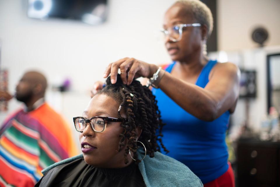 Entrepreneur and educator Erika Pryor gets her locs styled by Romayne Pearson at KiEssence Grande Beauty & Barber.