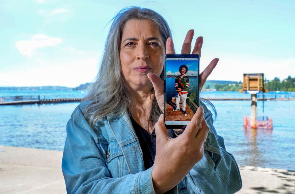 Jenine Lewis at Coulon Beach in May, with a photo of her son Elijah. His father died before he was born. When Elijah arrived, they called him a miracle baby.