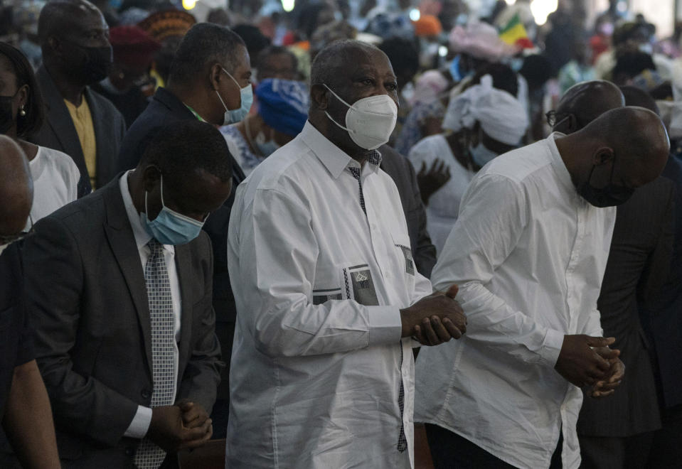 Former Ivorian president Laurent Gbagbo, center right, attends a Mass at the Saint Paul's cathedral in Abidjan, Ivory Coast, Sunday, June 20, 2021. Gbagbo, who has returned to the country after nearly a decade, was extradited to the International Criminal Court at The Hague in 2011 and spent eight years awaiting trial on war crimes charges. A judge acquitted him in 2019, saying prosecutors had failed to prove their case. (AP Photo/Leo Correa)