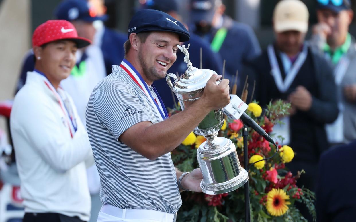 Bryson DeChambeau of the United States celebrates with the championship trophy after winning as low amateur John Pak of the United States - Getty Images