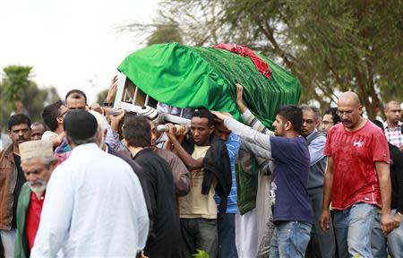 Relatives and Muslim faithful carry the slain body of Rehmad Mehbub, 18, who was killed in a crossfire between armed men and the police at the Westgate shopping mall, in Kenya's capital Nairobi September 22, 2013. REUTERS/Thomas Mukoya