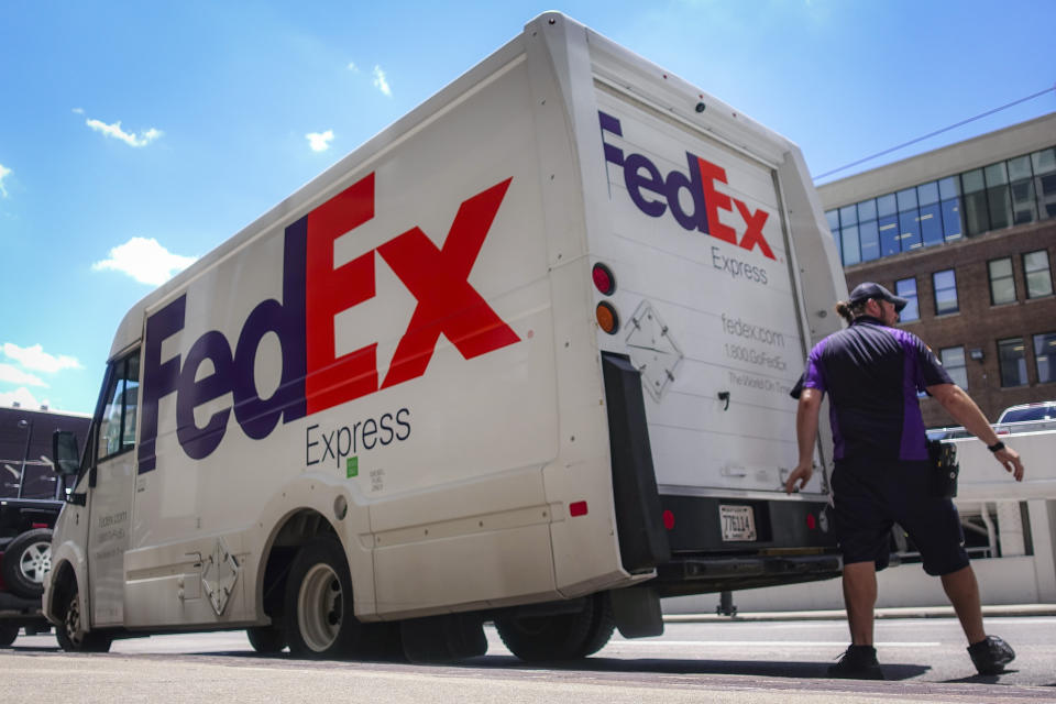 A FedEx delivery truck is loaded by an employee on the street, Tuesday, June 25, 2019, in downtown Cincinnati. FedEx Corp. (FDX) on Tuesday reported a fiscal fourth-quarter loss of $1.97 billion, after reporting a profit in the same period a year earlier. (AP Photo/John Minchillo)