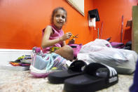 Delmis Benbow Tamayo, 8, finds a pair of children's scissors in a backpack with school supplies that was donated to her family, Tuesday, Feb. 21, 2023, in Hialeah, Fla. Delmis, her mother and two siblings arrived by sea to the U.S. from Cuba. Delmis started school the following day. (AP Photo/Marta Lavandier)