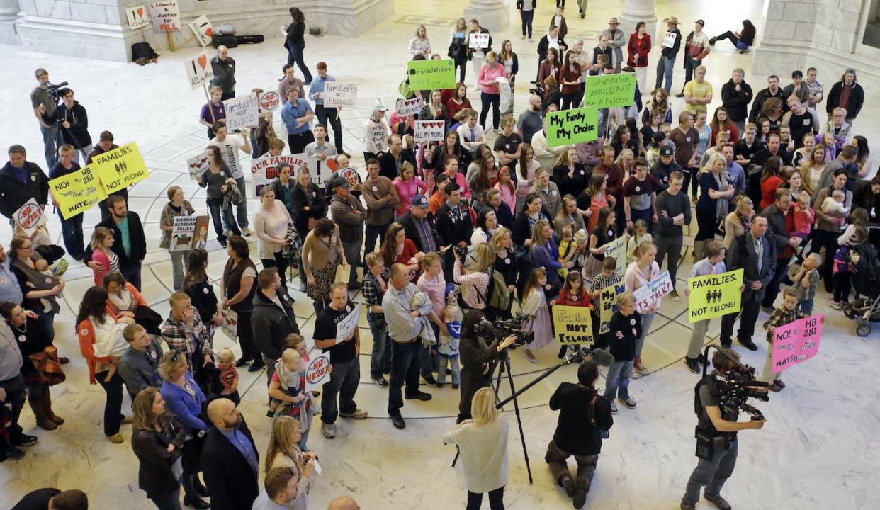 A group of protesters stands inside the Utah State Capitol in 2016, criticizing a proposal to make polygamy a felony again. <a href="https://newsroom.ap.org/detail/UtahPolygamyLaw/74a8a9ce06dc49f4b58f4a9dd8cf598f/photo?Query=polygamy%20protest&mediaType=photo&sortBy=&dateRange=Anytime&totalCount=31&currentItemNo=14" rel="nofollow noopener" target="_blank" data-ylk="slk:Rick Bowmer/AP;elm:context_link;itc:0;sec:content-canvas" class="link ">Rick Bowmer/AP</a>
