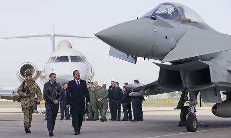 Prime Minister David Cameron (3rd L) looks at an RAF Eurofighter Typhoon fighter jet during his visit to Royal Air Force station RAF Northolt in London, Britain November 23, 2015. REUTERS/Justin Tallis/pool