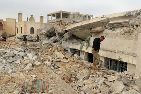 People inspect a damaged mosque after an airstrike on the rebel-held village of al-Jina, Aleppo province in northwest Syria March 17, 2017. REUTERS/Ammar Abdullah