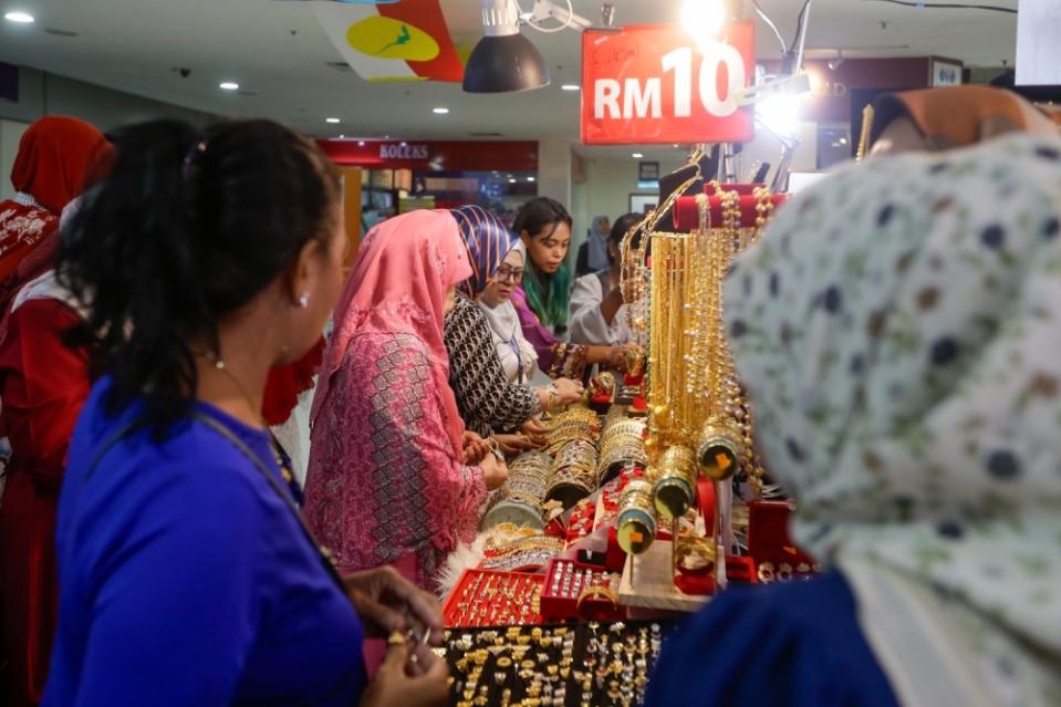 Para delegasi berbelanja di berbagai stan selama Sidang Umum PBB 2024 di World Trade Center di Kuala Lumpur. 23 Agustus 2024. — Foto oleh Raymond Manuel