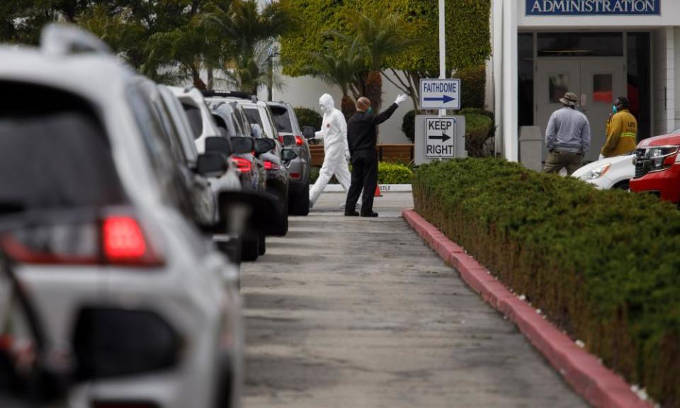 Medical personnel distribute kits at a new drive-through testing station for the coronavirus at the Crenshaw Christian Center in Los Angeles.