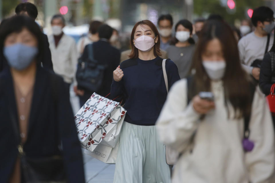 People wearing face masks to help curb the spread of the coronavirus walk at the Ginza shopping district on Tokyo Monday, Nov. 8, 2021. (AP Photo/Koji Sasahara)