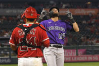Colorado Rockies' Sam Hilliard, right, gestures as he scores after hitting a three-run home run as Los Angeles Angels catcher Kurt Suzuki stands at the plate during the fourth inning of a baseball game Tuesday, July 27, 2021, in Anaheim, Calif. (AP Photo/Mark J. Terrill)