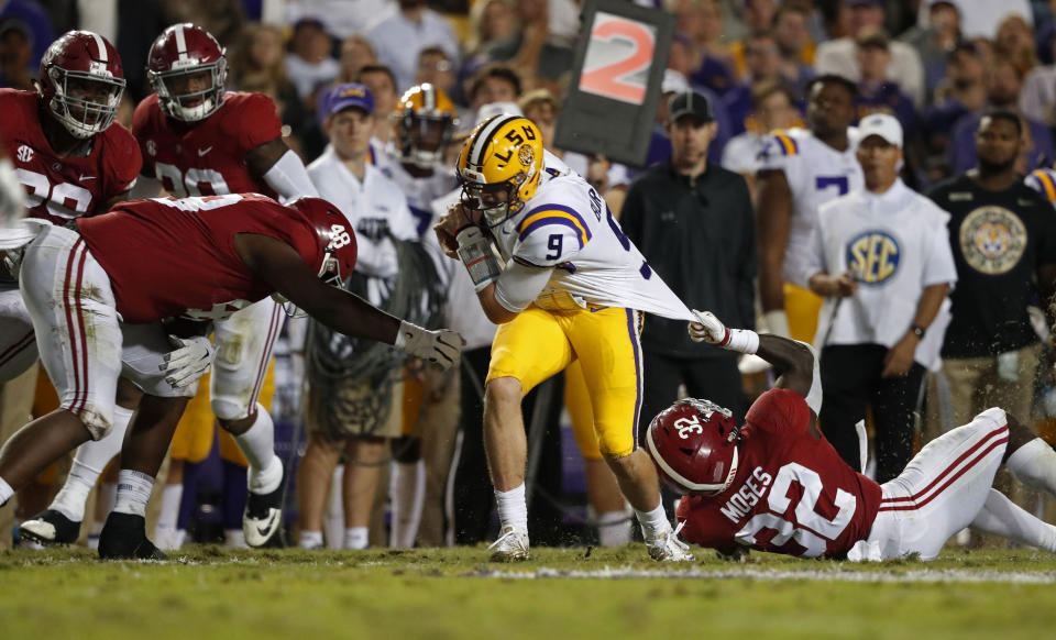 Alabama linebacker Dylan Moses (32) tries to tackle LSU quarterback Joe Burrow (9) by his jersey as defensive lineman Phidarian Mathis (48) closes in, during the second half of an NCAA college football game in Baton Rouge, La., Saturday, Nov. 3, 2018. Alabama won 29-0. (AP Photo/Gerald Herbert)