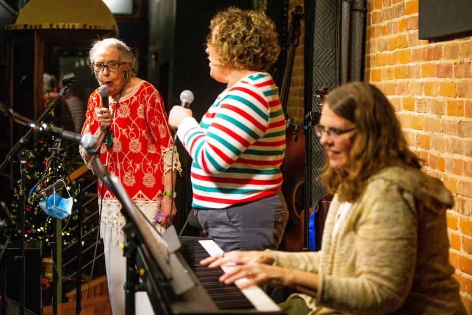 Gina Weigand, left, and Kim Morrison sing with Ramona Lichtenbarger playing the keyboard during an open mic night Wednesday, Dec. 15, 2021, at Wild Rose Moon in Plymouth.