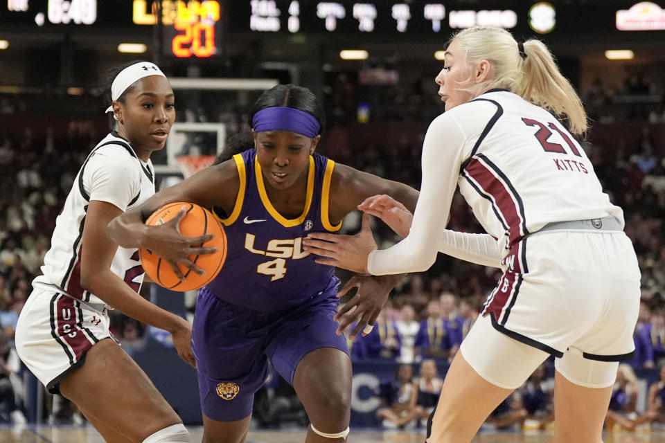 LSU guard Flau'jae Johnson drives to the basket between South Carolina guard Bree Hall and forward Chloe Kitts during the first half of an NCAA college basketball game at the Southeastern Conference women's tournament final Sunday, March 10, 2024, in Greenville, S.C. (AP Photo/Chris Carlson)