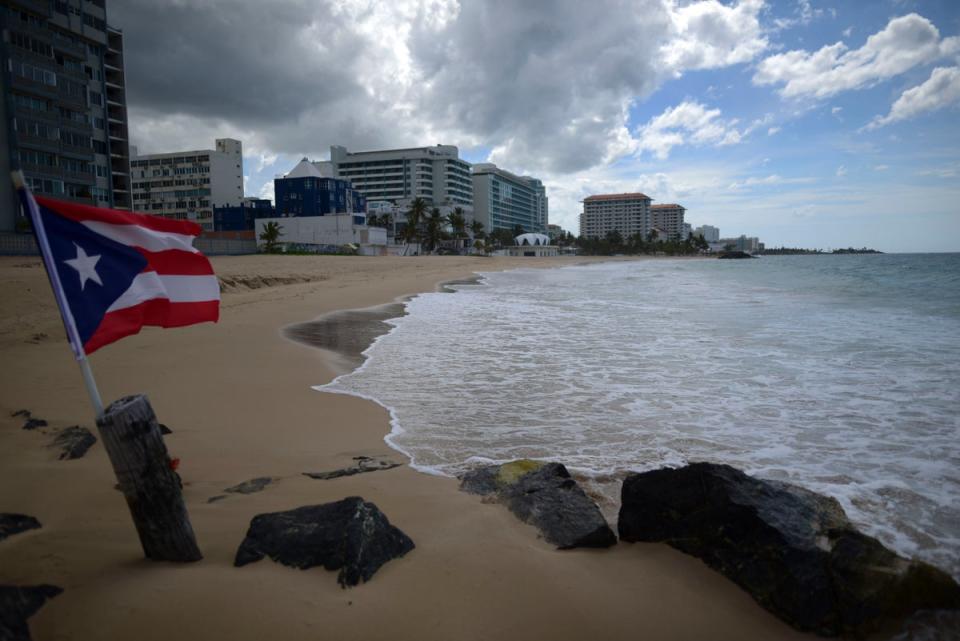 A Puerto Rican flag on an empty beach at Ocean Park, San Juan, Puerto Rico (stock image) There have been eight drowning deaths at Puerto Rican beaches in 2024 (Copyright 2020 The Associated Press. All rights reserved.)