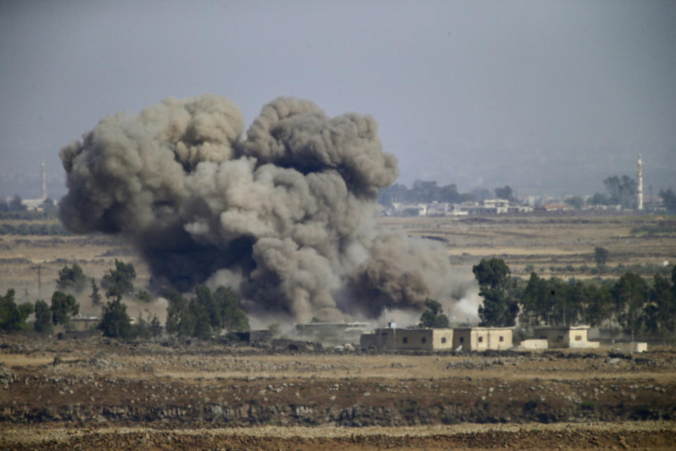 Smoke and explosions from the fighting between forces loyal to Syrian President Bashar Assad and rebels in the Darra province can be seen from the Israeli-controlled Golan Heights, Wednesday, July 25, 2018. (AP Photo/Ariel Schalit)