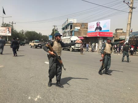 Afghan policemen keep watch near the site of a blast in Kabul, Afghanistan