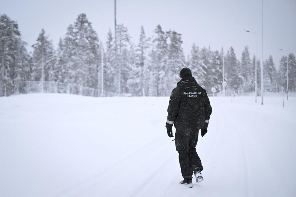 A Finnish Border Guard walks in the snow at the Raja-Jooseppi international border crossing station between Russia and Finland, in Inari, northern Finland, Saturday, Nov. 25, 2023. The European Union’s border agency says that it will send dozens of officers and equipment as reinforcements to Finland to help police its borders amid suspicion that Russia is behind an influx of migrants arriving to the country. (Emmi Korhonen/Lehtikuva via AP)