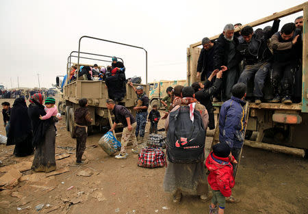 Displaced Iraqi people who fled their homes during a battle between Iraqi forces and Islamic State militants, arrive at a checkpoint to be transfer to Hammam al-Alil camp, in Mosul, Iraq, March 20, 2017. REUTERS/Thaier Al-Sudani