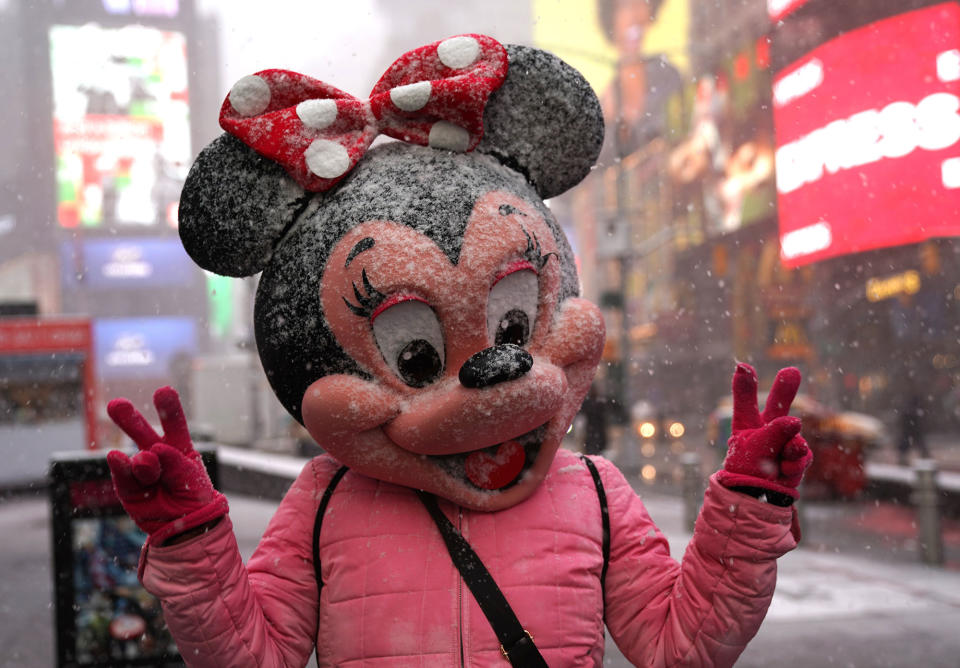 <p>A person in a Minnie Mouse mask poses Times Square in New York on March 21, 2018, as the fourth nor’easter in a month hits the tri-state area on the first full day of spring. (Photo: Timothy A. Clary/AFP/Getty Images) </p>