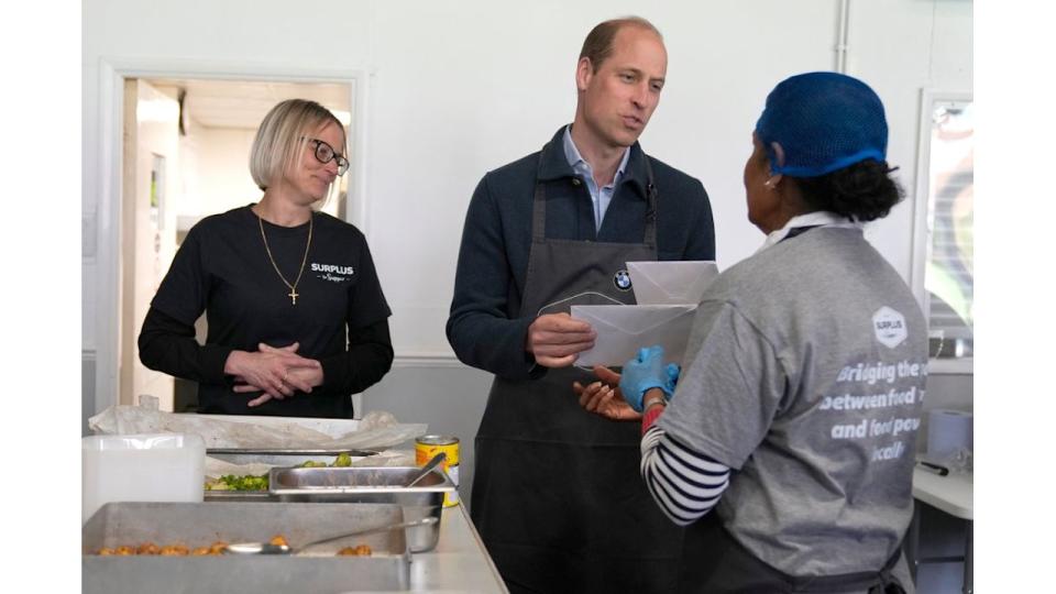 The Prince accepts a get-well card for his wife when visiting a food distribution charity in April this year