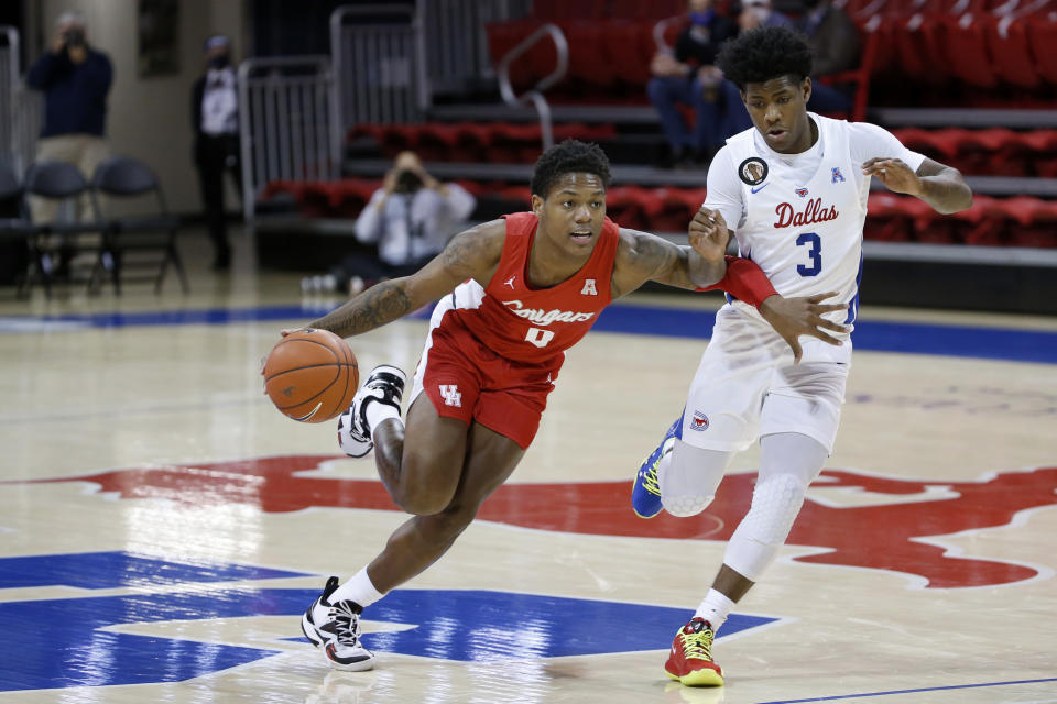 Houston guard Marcus Sasser (0) drives past SMU guard Kendric Davis (3) during the first half of an NCAA college basketball game in Dallas, Sunday, Jan. 3, 2021. (AP Photo/Roger Steinman)