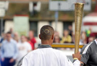 In this handout image provided by LOCOG, Torchbearer Kasey Hagan wears a design of the Olympic Rings in his hairstyle as he carries the Olympic Flame on the Torch Relay leg between Felixstowe and Ipswich on Day 48 of the London 2012 Olympic Torch Relay on July 5, 2012 in Felixstowe, England. The Olympic Flame is now on day 48 of a 70-day relay involving 8,000 torchbearers covering 8,000 miles. (Photo by LOCOG via Getty Images)