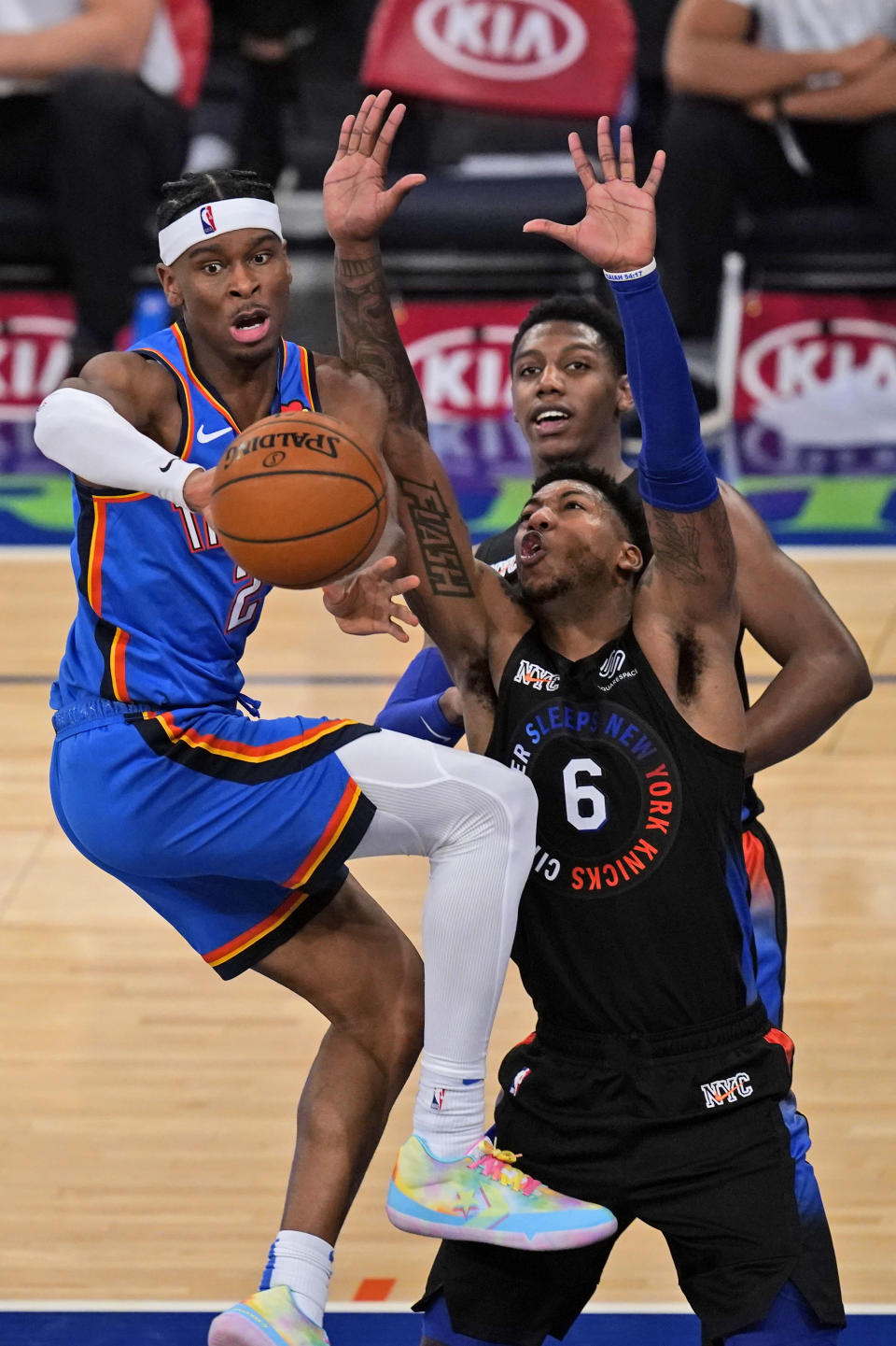 Oklahoma City Thunder's Shai Gilgeous-Alexander, left, passes around New York Knicks defenders during the first half of an NBA basketball game, Friday, Jan. 8, 2021, in New York. (AP Photo/Seth Wenig, Pool)