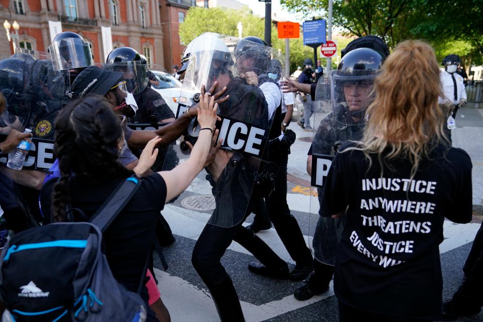 Demonstrators clash with police as they protest the death of George Floyd, Saturday, May 30, 2020, near the White House in Washington.