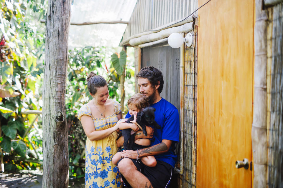 Andrew Lawson, de 29 años, quien en las últimas semanas ha perdido la mayor parte de sus ingresos, con Juliana, su esposa embarazada, y Vesuvianite, su hijo de dos años, afuera de su casa en Ocean View, Hawái, el 29 de marzo de 2020. (Megan Spelman/The New York Times)