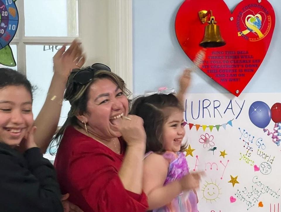 Young cancer patient Amy Galeano (right) rejoices with her mother Karina and sister Alondra at her "end of chemo" celebration at the Kids Cancer Foundation center.