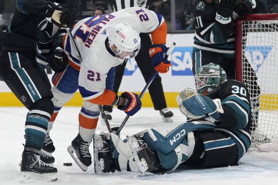 New York Islanders center Kyle Palmieri (21) falls forward in front of San Jose Sharks goaltender Magnus Chrona (30) during the second period of an NHL hockey game in San Jose, Calif., Thursday, March 7, 2024. (AP Photo/Jeff Chiu)