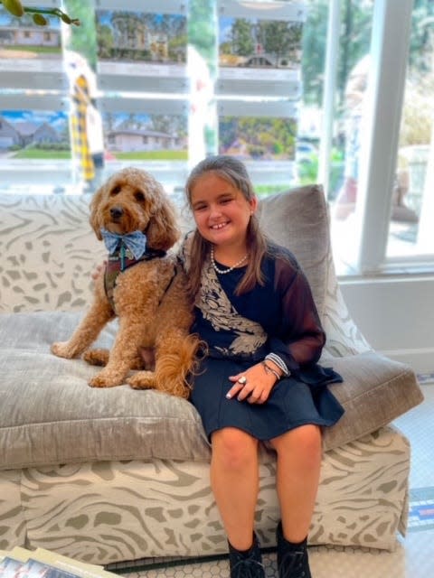 Parker Bennefield with her dog modeling one of her bowtie creations