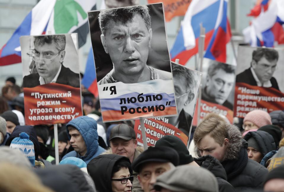 Demonstrators, with flags of different opposition movements and portraits of Boris Nemtsov, march in memory of opposition leader Boris Nemtsov in Moscow, Russia, Sunday, Feb. 24, 2019. Thousands of Russians took to the streets of downtown Moscow to mark four years since Nemtsov was gunned down outside the Kremlin. The words on the central portrait reads "I love Russia". (AP Photo/Pavel Golovkin)