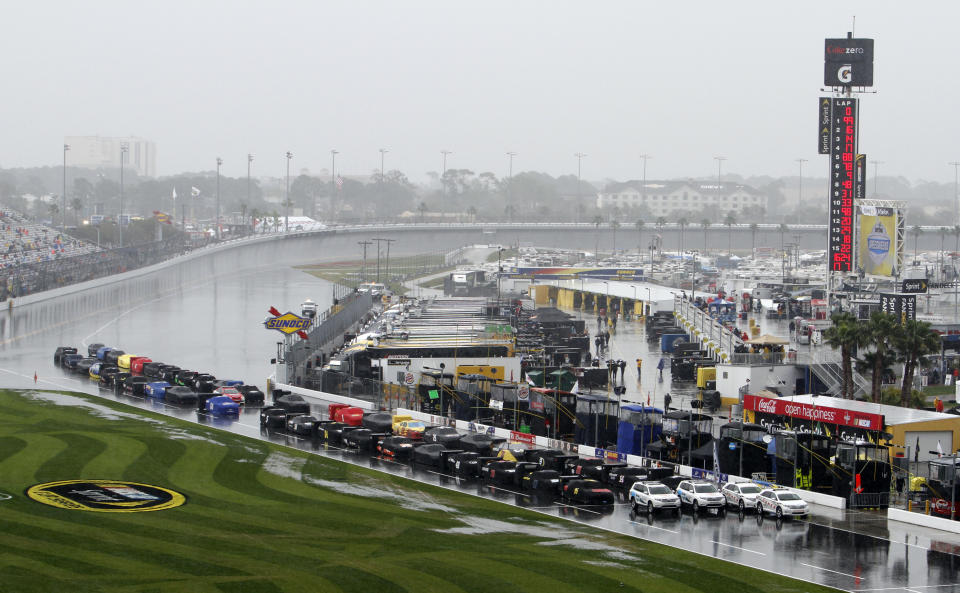 Race cars are parked and covered on pit road during a rain delay before the NASCAR Daytona 500 auto race in Daytona Beach, Fla., Sunday, Feb. 26, 2012. (AP Photo/David Graham)