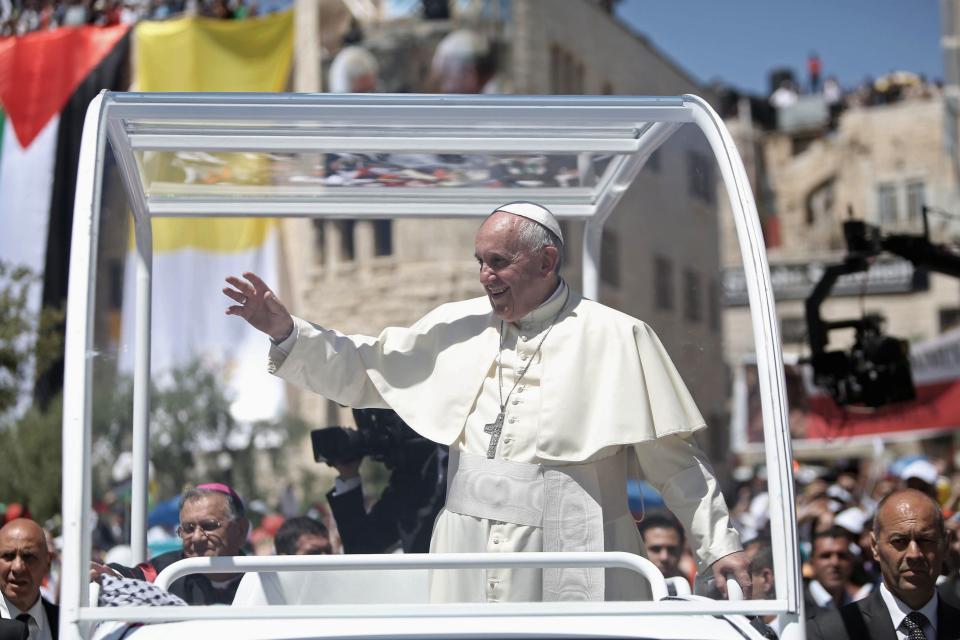 Pope Francis waves to the crowd as he arrives to lead an open-air mass in the Manger Square, next to the Nativity Church in the West Bank town of Bethlehem