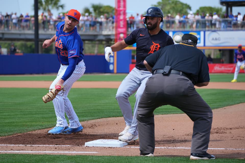 An errant pickoff throw by New York Mets pitcher Austin Adams gets by first baseman Pete Alonso (20) as Detroit Tigers right fielder Riley Greene (31) gets back safely in the fourth inning at Clover Park in Port St. Lucie, Florida, on Sunday, March 10, 2024.