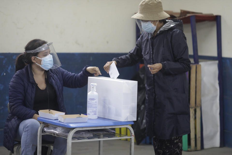 A voter casts her ballot during a run-off presidential election in Lima, Peru, Sunday, June 6, 2021. Peruvians vote Sunday to choose between Keiko Fujimori, the daughter of jailed ex-President Alberto Fujimori, and Pedro Castillo, a political novice that until recent was a rural schoolteacher. (AP Photo/Guadalupe Pardo)