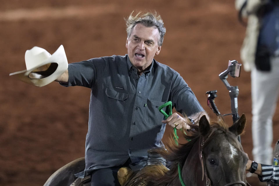 Brazilian President Jair Bolsonaro, who is running for a second term, rides a horse at the the Barretos Rodeo International Festival in Barretos, Sao Paulo state Brazil, Friday, Aug. 26, 2022. Brazil's general elections are scheduled for Oct. 2, 2022. (AP Photo/Andre Penner)