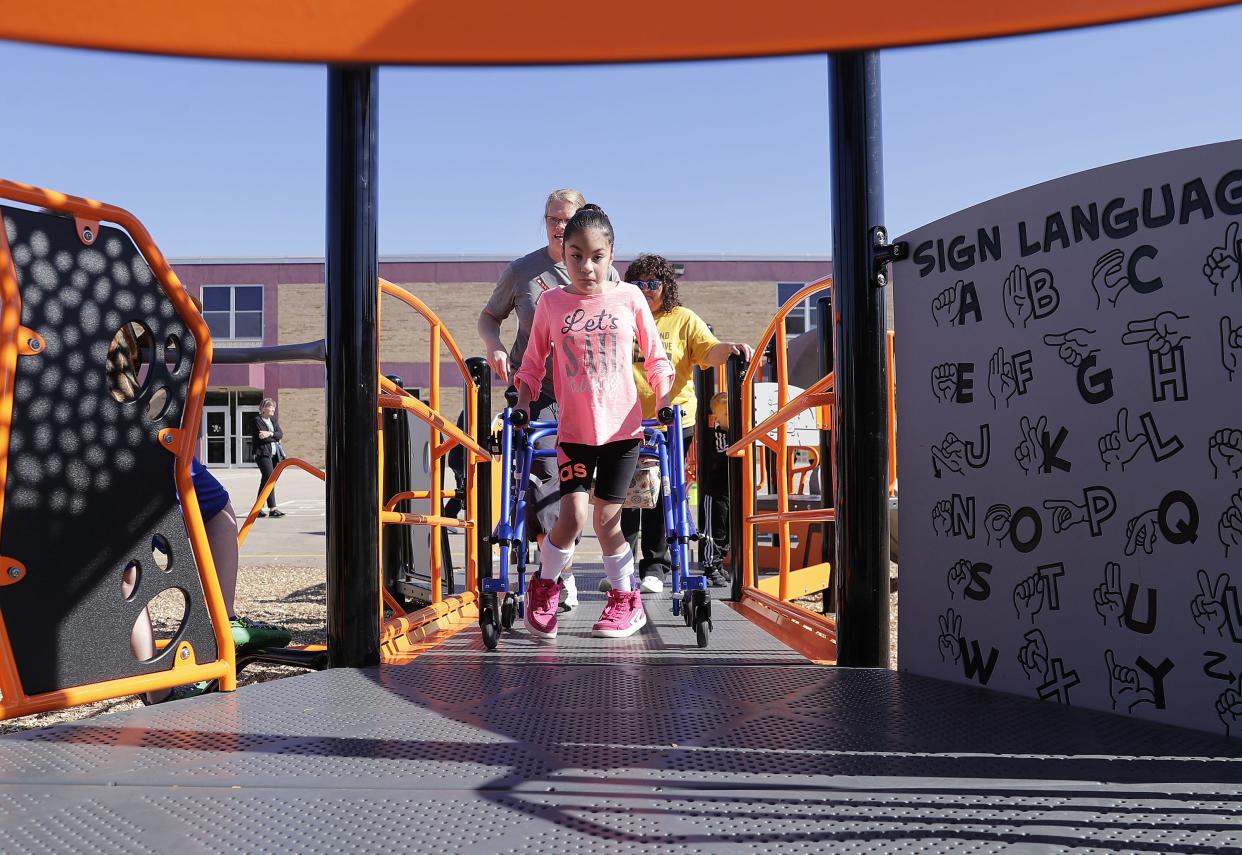 Alondra Cruz tries a ramp while entering an inclusive playground at Highlands Odyssey Elementary School in Appleton on Monday.