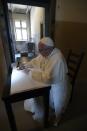 Pope Francis writes in the guest book at the end of his visit to the Nazi German death camp of Auschwitz in Oswiecim, Poland, Friday, July 29, 2016. Pope Francis paid a somber visit to the Nazi German death camp of Auschwitz-Birkenau July 29. (L'Osservatore Romano /Pool Photo via AP)