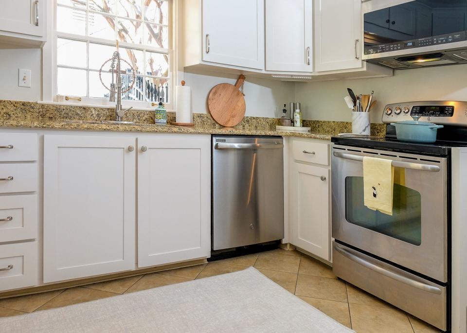 The kitchen has a fresh look with new cabinets that go to the ceiling to allow for more storage.