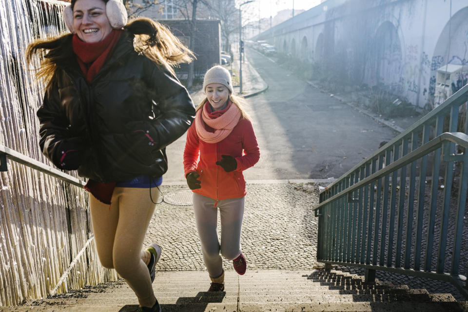 Urban fitness, two women running up stairs as part of a workout.