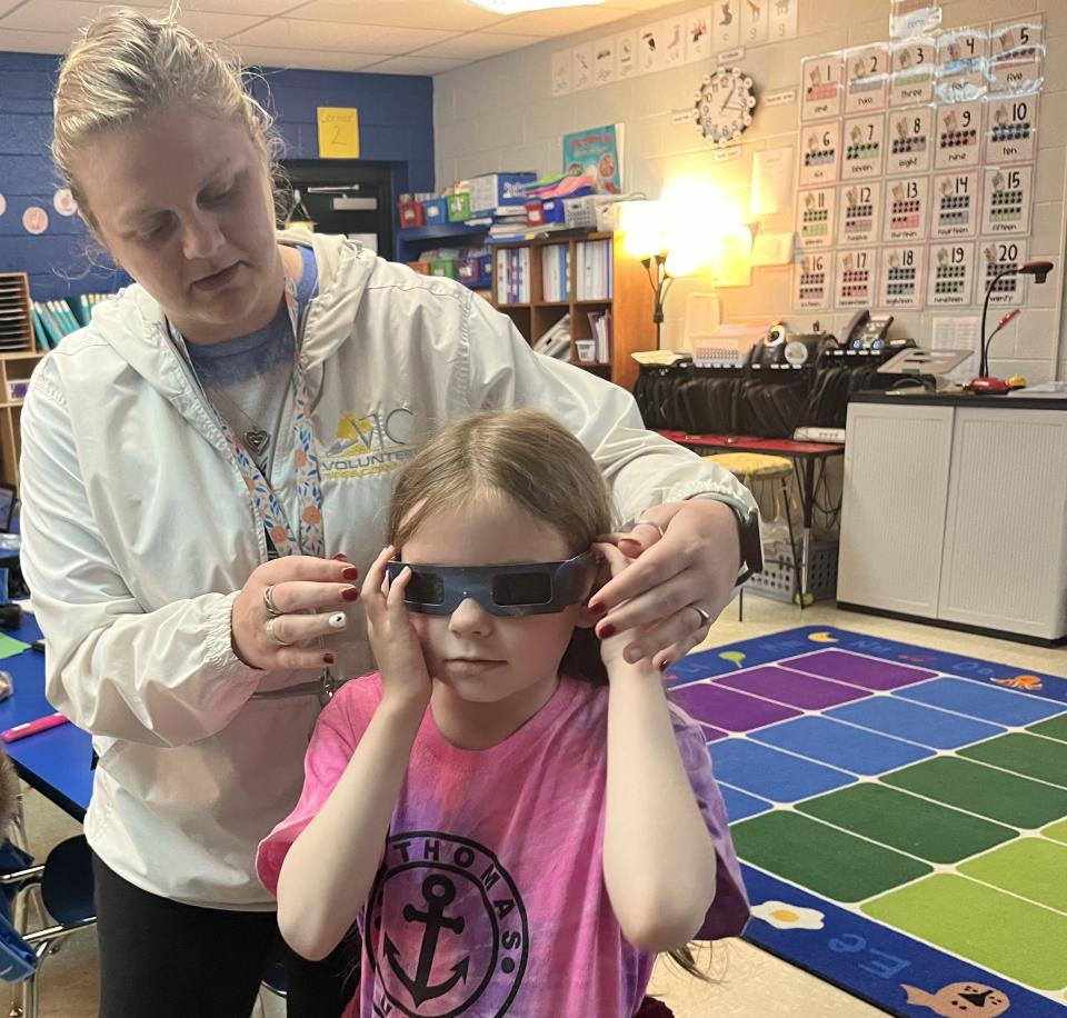 Teacher Jessica Lovett adjusts protective glasses for Lillian Barnes, 8, who tried on her eyewear ahead of the partial solar eclipse at Riverside Elementary School on April 8, 2024 in Columbia, Tenn.