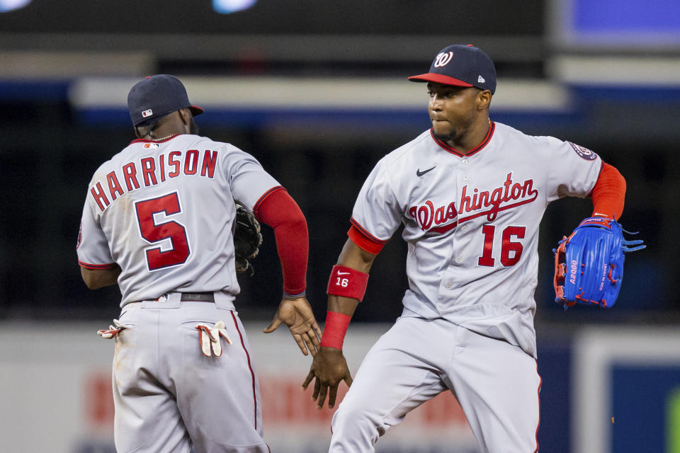 Washington Nationals center fielder Victor Robles (16) and second baseman Josh Harrison (5) celebrate a victory over the Miami Marlins in a baseball game, Thursday, June 24, 2021, in Miami. (AP Photo/Mary Holt)