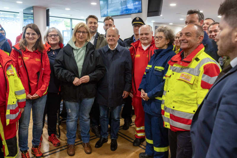 German Chancellor Olaf Scholz (C) and Anke Rehlinger (L), Minister President of the Saarland, visit the Saarbruecken stadium to see the emergency services deployed to help with the Saar floods. Helmut Fricke/dpa