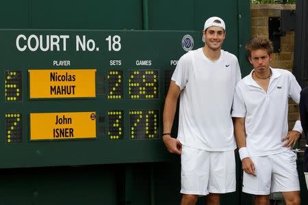 John Isner of the U.S. (L) and France's Nicolas Mahut pose for a photograph next to the scoreboard on court 18 after their record breaking match at the 2010 Wimbledon tennis championships in London, June 24, 2010. REUTERS/Suzanne Plunkett/Files