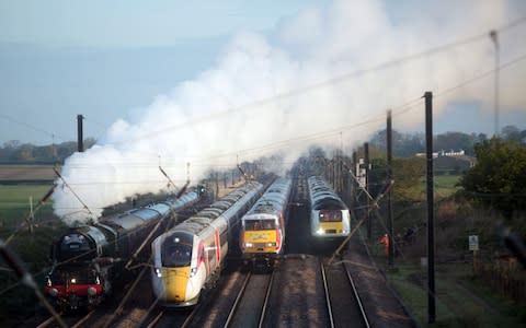 Four generations of train, including the Flying Scotsman steam train, travel down the track in Yorkshire - Credit: David Parry/PA