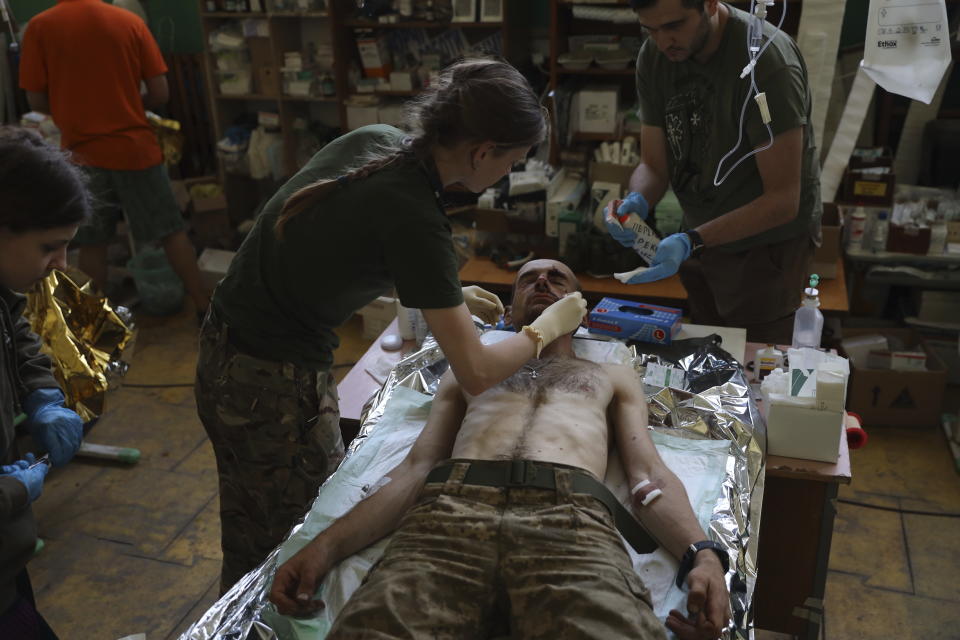 Medics help an injured Ukrainian serviceman in a frontline medical stabilization point in Zaporizhzhia region, Ukraine, Thursday, July 27, 2023. (AP Photo/Kateryna Klochko)