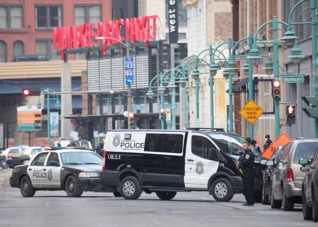 Police work on the scene after an off-duty police detective was shot trying to stop an attempted carjacking on Thursday near the intersection of North Water Street and East Buffalo Street in Milwaukee.