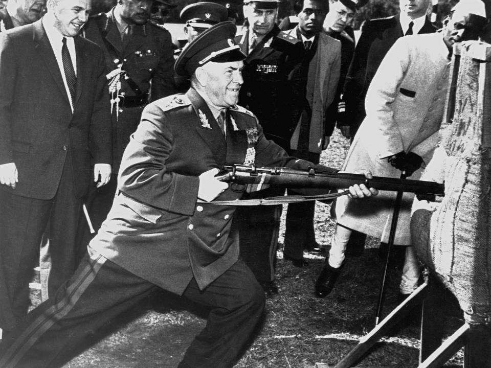 Soviet Defense Minister Georgy Zhukov thrusts the bayonet of a rifle into a dummy as a group looks on